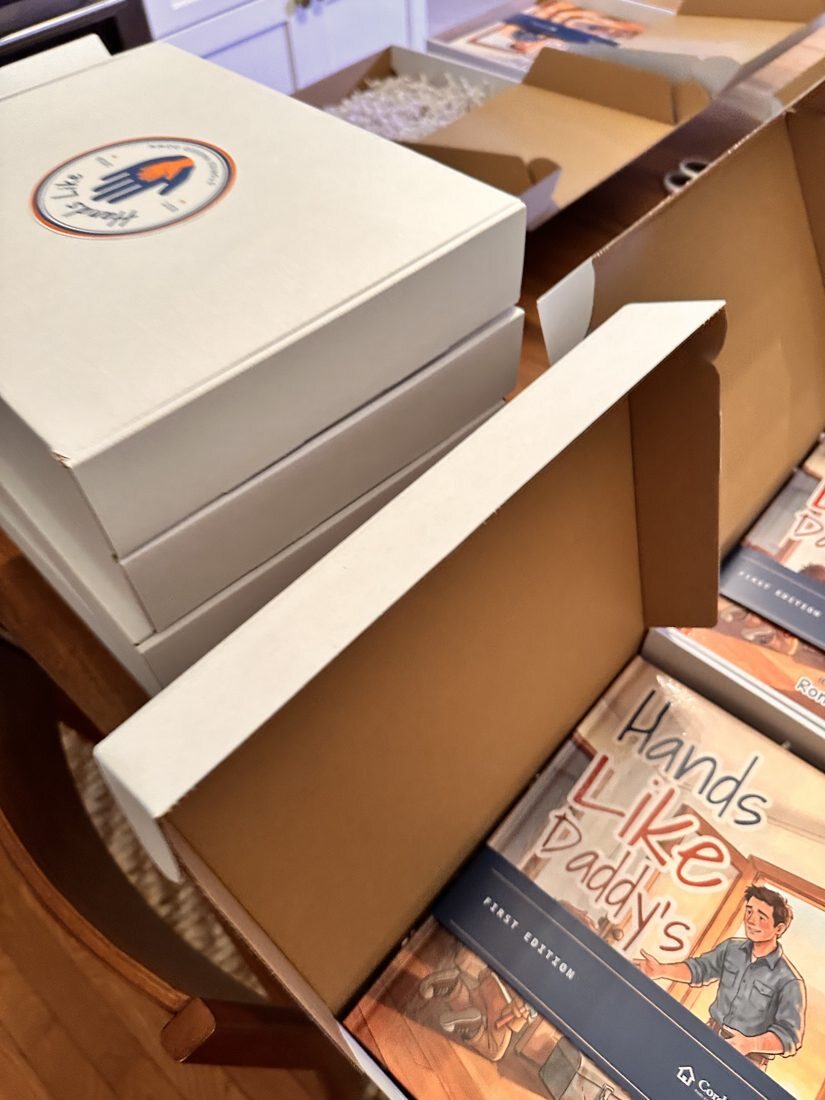 A row of open mailer boxes with books inside